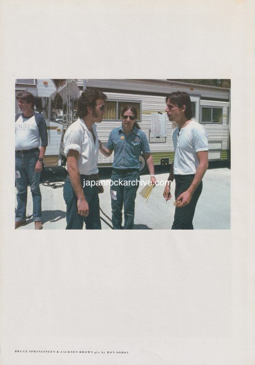 bruce springsteen and jackson browne standing outdoors with a trailer in the background