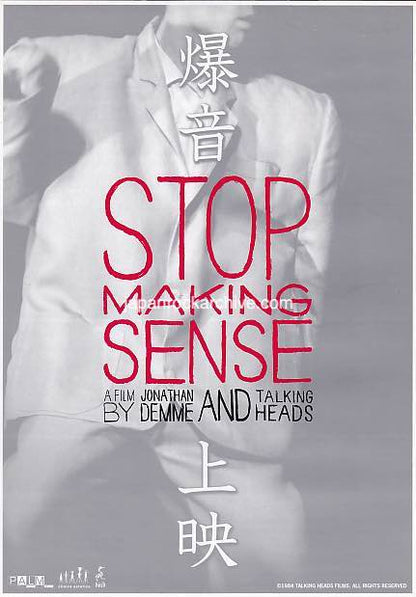 Japanese movie flyer for Talking Heads 'Stop Making Sense' featuring David Byrne in a big suit in the foreground with the title and  text in red and white.
